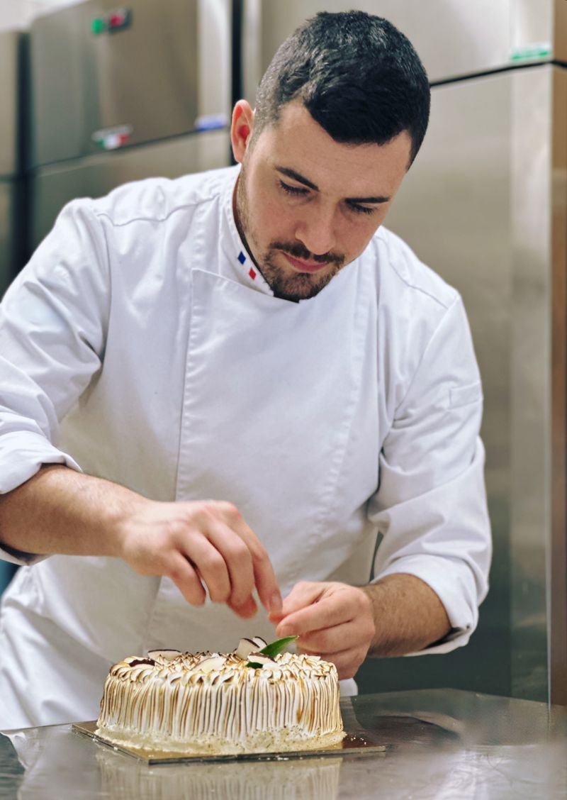 Florian Berger che finisce la guarnizione di una torta