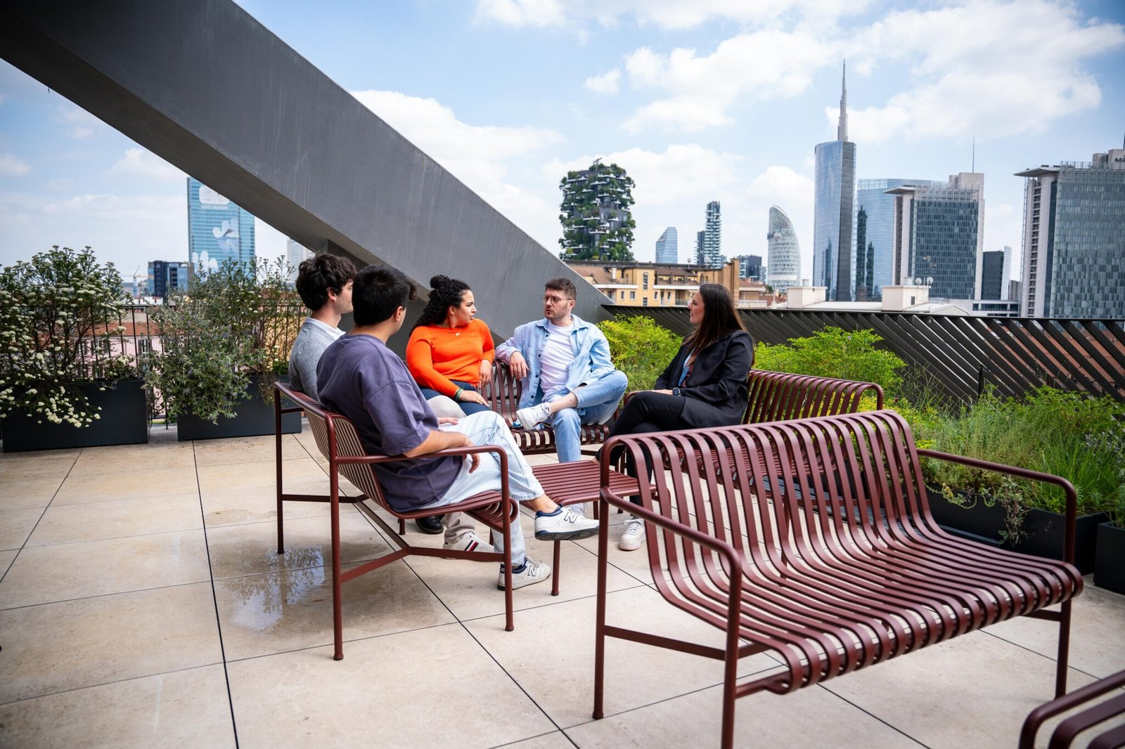 Alcuni ragazzi del team di Satispay parlano seduti sul rooftop dell'ufficio.