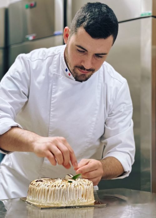 Florian Berger che finisce la guarnizione di una torta