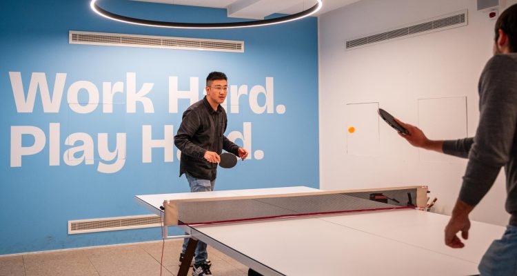 Due ragazzi che giocano a ping pong negli uffici di satispay